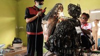 Sejumlah pelajar nampak sibuk di dalam bengkel SMK Karya Utama Karawang. Dibantu sejumlah pembimbing, mereka membuat robot dari onderdil bekas. 