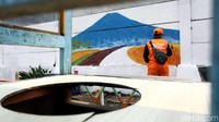 Petugas PPSU nampak membuat mural bertema lingkungan di Jalan Utan Jati, Kalideres, Jakarta Barat, Senin (24/6/2019).