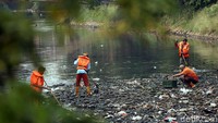 Sejumlah petugas oranye membersihkan sampah yang menyebar di Kali Mati, Karet Tengsin, Jakarta, Senin (24/6/2019).