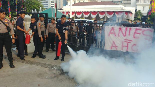 Petugas keamanan Balai Kota memadamkan api dengan APAR.
