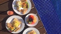 Saat di Bali, perempuan berdarah Minang ini sarapan dengan menu Barat di pinggir kolam renang. Ada roti, telur, sosis, kentang goreng, hingga buah segar yang jadi pilihan Whulan. Foto: Instagram whulandary