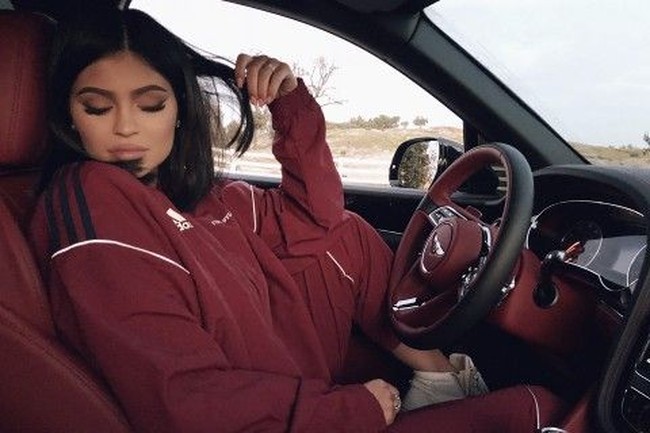 Kylie Jenner memakai trainer merah Adidas yang senada dengan warna merah interior Bentley-nya. (Foto: Instagram/@kyliejenner)