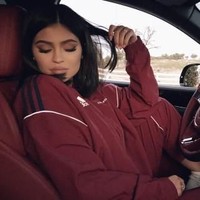 Kylie Jenner memakai trainer merah Adidas yang senada dengan warna merah interior Bentley-nya. (Foto: Instagram/@kyliejenner)