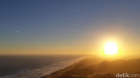 Matahari perlahan turun. Di balik bukit berhadapan dengan pantai, garis horizon mulai kabur. Warna jingga dan biru menyatu dan membuat pengunjung terpesona. Bonauli/detikcom)