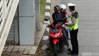 Pengendara motor nampak ditilang polisi karena nekat menerobos jalur busway di Jl. Daan Mogot, Jakarta Barat.