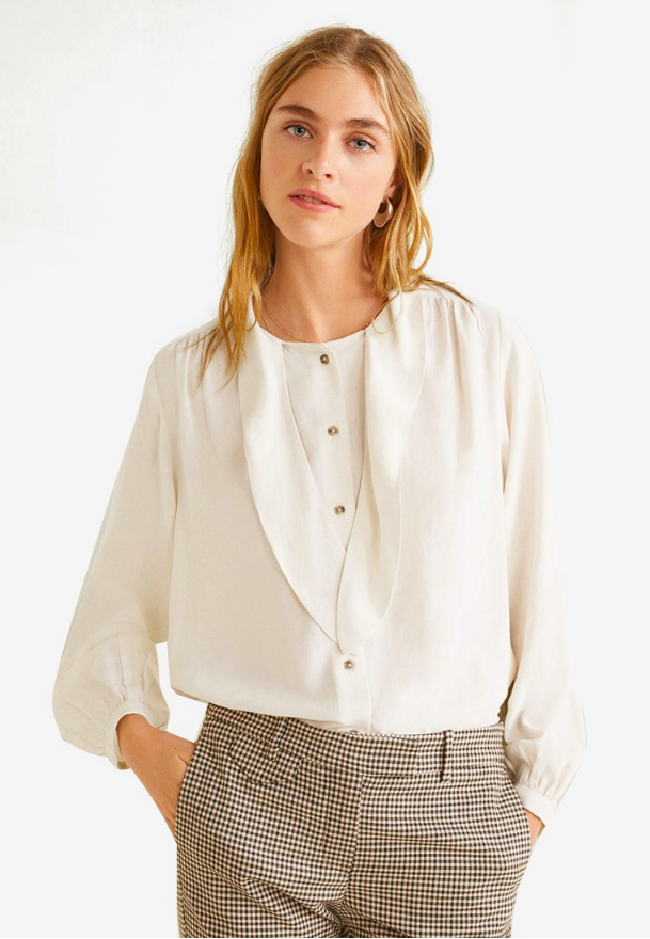 Mango pun menyediakan blus putih dengan beragam detail dan potongan. Untuk Anda yang ingin membeli blus yang fleksibel untuk digunakan ke berbagai kesempatan dapat melirik Tie-Neck Blouse yang sedang diskon dari Rp 700 ribu menjadi Rp 650 ribuan. Foto: Zalora