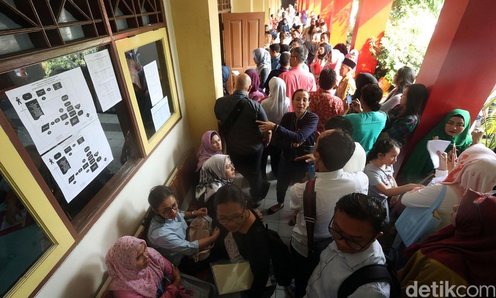 Ratusan orang mengantre Pendaftaran Penerimaan Peserta Didik Baru (PPDB) DKI Jalur Zonasi di SMPN 115 Jakarta. Mereka berebut kursi SMPN favorit di DKI.
