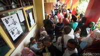 Antrean mengular panjang di lorong sekolah.