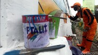 Seorang petugas juga membuat mural bergambar gunung.