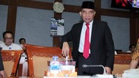 Muhadjir Effendy menghadiri rapat kerja dengan mengenakan setelan jas. Mendikbud juga memakai peci warna hitam.