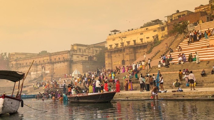 Woman doing spiritual ceremonies on the ghats of the holy river Ganges in Varanasi in India