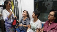 Salah satu peserta aksi menyapa penumpang dan menjelaskan tentang kebaya.