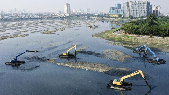 Sejumlah pekerja dengan menggunakan alat berat melakukan pengerukan lumpur di Waduk Pluit, Jakarta, Selasa (25/6/2019).  Pengerukkan waduk Pluit yang mengalami pendangkalan akibat sedimen yang mengendap di dasar waduk ditargetkan rampung November 2019. ANTARA FOTO/Nova Wahyudi/ama.