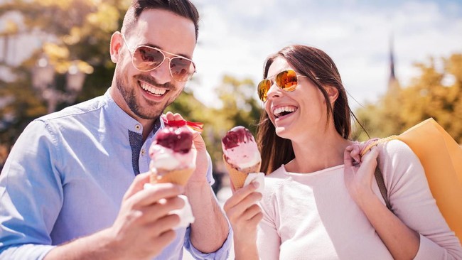 Couple eating pizza snack outdoors.They are sharing pizza and eating.