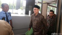 Lukman Hakim tiba dengan mengenakan peci dan kemeja batik berwarna cokelat.