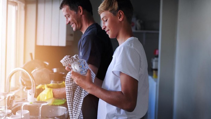 Cropped shot of a father and son cleaning dishes together at home