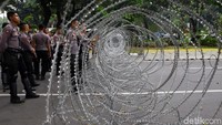Pasukan polisi berjaga di depan kawat berduri yang terpasang di area sekitar gedung MK.