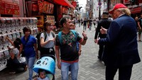 Sejumlah warga menyapa sosok Donald Trump gadungan saat bertemu di kota Osaka, Jepang.