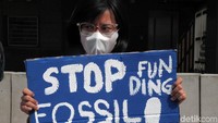 Seorang demonstran membentangkan poster.