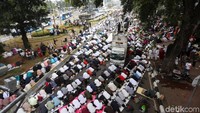 Massa aksi menggelar salat Zuhur berjamaan di Jalan Medan Merdeka Barat, Jakarta, Rabu (26/6/2019).