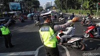 Polisi mengatur lalu lintas.