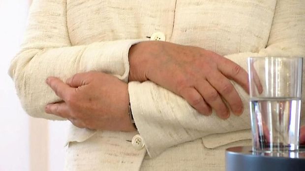 Angela Merkel melipat kedua tangannya saat kembali kejang-kejang ketika berdiri di sebelah Presiden Jerman, Frank-Walter Steinmeier