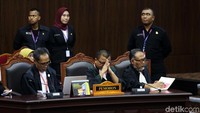 Tim hukum Prabowo, Bambang Widjojanto dan Denny Indrayana menyimak pembacaan amar putusan oleh Ketua MK Anwar Usman.