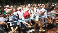 Azan dilantunkan dari mobil komando, massa aksi berbaris untuk antre berwudhu.