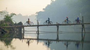 Potret sejumlah warga yang melintasi jembatan di salah satu daerah di Indonesia ini tak kalah memukau. Kondisi air yang jernih memantulkan refleksi warga yang melintasi jembatan tersebut. Istimewa/Dok. Boredpanda/ bimopradityo.