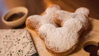 Disneyland California punya camilan bentuk kepala Mickey Mouse. Berupa beignets dengan taburan gula halus. Rasanya bukan hanya original tapi juga beberapa rasa lain yang kerap bergantu sesuai musim. Foto: The Walt Disney Company