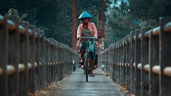 Potret seorang nenek menggunakan sepeda saat sedang melintasi jembatan di salah satu daerah di Thailand. Istimewa/Dok. Boredpanda/ blackustad.