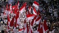 Bendera merah putih nampak dibawa oleh sejumlah peserta aksi yang mulai merapat di area sekitar Patung Kuda.