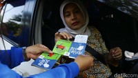 Pengemudi menerima hasil uji emisi kendaraanya.