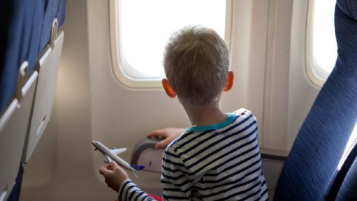 little boy in the plane looking out the window