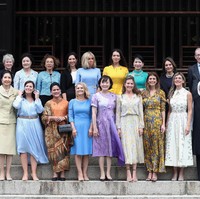 Ia memakai atasan berpotongan baju kurung yang dipadu dengan  sarung dan selendang bermotif senada. Ibu tiga anak ini lalu menyempurnakan gayanya dengan statement necklace dan tas hitam bersiluet klasik yang dihiasi motif anyaman. (Foto: Du Xiaoyi/Pool via Reuters)