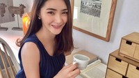 Penasaran gaya Nattaya saat ngopi? Dengan outfit rapih, ia memberi emoji kopi dalam unggahannya ini. Foto: Facebook Nattaya Nat