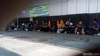 Antrean yang cukup panjang membuat warga yang tak kebagian tempat duduk memilih mengantre sambil duduk-duduk di halaman gedung Kejari Jaksel.