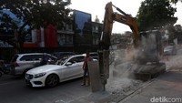 Alat berat dikerahkan untuk menghancurkan bahu jalan.