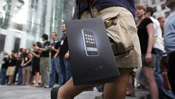 Yang sudah membeli pun bisa dengan bangga menenteng tas belanja berisikan iPhone generasi pertama, menggoda orang lain yang masih antre. (Foto: Michael Nagle/Getty Images)