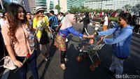 Para relawan membagikan bunga mawar kepada pengunjung CFD Bundaran HI.