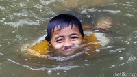 Surutnya ketinggian air dimanfaatkan anak-anak untuk bermain.