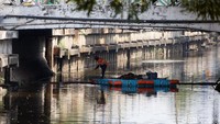 Petugas PPSU membersihkan sampah di Kali Item Kemayoran, Jakarta, Senin (1/7/2019).