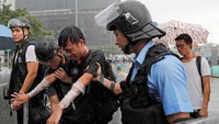 Seorang pengunjuk rasa yang terkena semprotan lada diamankan oleh petugas kepolisian. Tyrone Siu/Reuters.