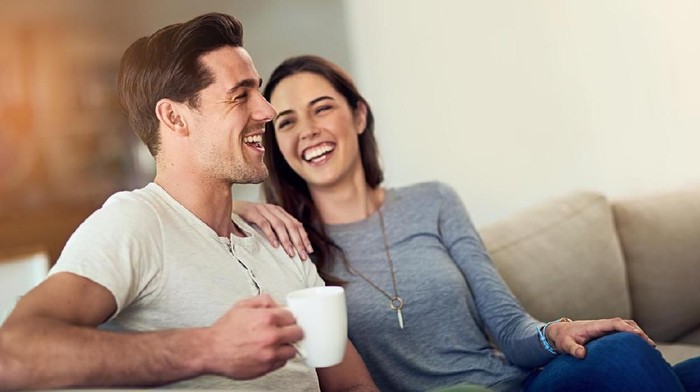 1028900504 Happy millennial couple laughing reading good positive funny information in paper bills or letters, young smiling man and woman having fun with documents and laptop while planning budget finances