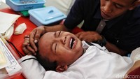 Seorang anak menangis saat disunat. 