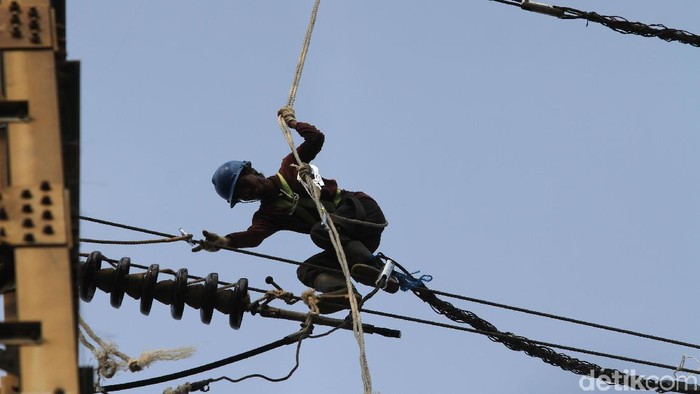 Sejumlah petugas PLN tengah melakukan reconductoring tower listrik jalur Karet-Angke, Jakarta, Selasa (2/7). Mereka beraksi di ketinggian layaknya spiderman.