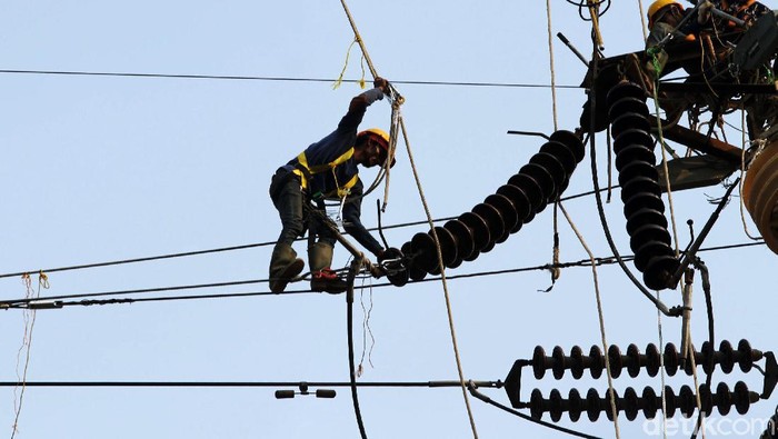 Sejumlah petugas PLN tengah melakukan reconductoring tower listrik jalur Karet-Angke, Jakarta, Selasa (2/7). Mereka beraksi di ketinggian layaknya spiderman.