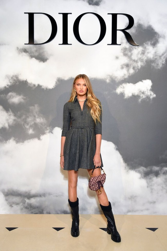 Model Victorias Secret Romee Strijd memilih gaun abu-abu berpotongan minimalis. Ia menyempurnakan gayanya dengan saddle bag dan boots hitam. (Foto: dok. Dior)