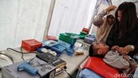 Para orang tua berusaha menenangkan anaknya yang terus menangis saat proses disunat.
