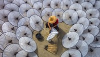 Payung tak hanya menjadi alat untuk melindungi tubuh dari hujan. Kerajinan payung hias juga menjadi salah satu buah tangan favorit bagi wisatawan. Seperti foto ini yang menampilkan seorang perajin tengah membuat kerajinan payung hias di Myanmar. Istimewa/Dok. Boredpanda/Agora Photo/@aungthuya.